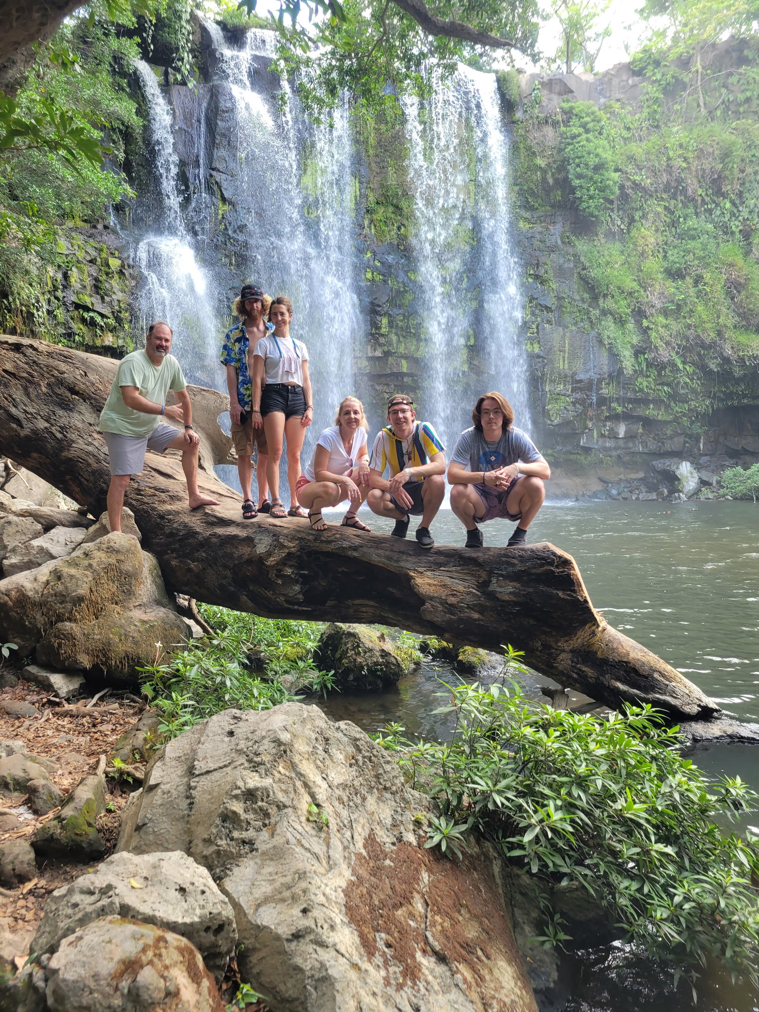 Cheryl with family at a tropical waterfall